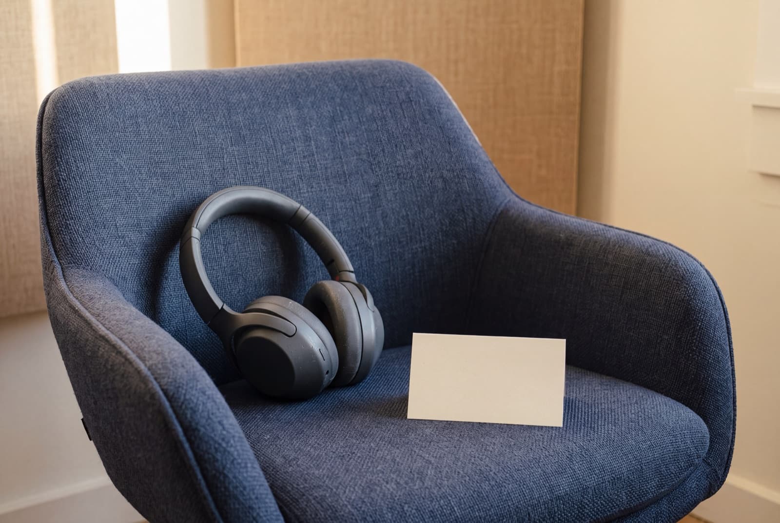 An empty guest chair with plain headphones and a blank prep card before the first interview